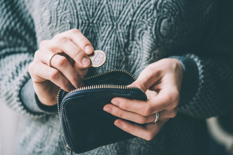 Hands,Holding,One,Euro,Coin,And,Small,Money,Pouch.,Toned