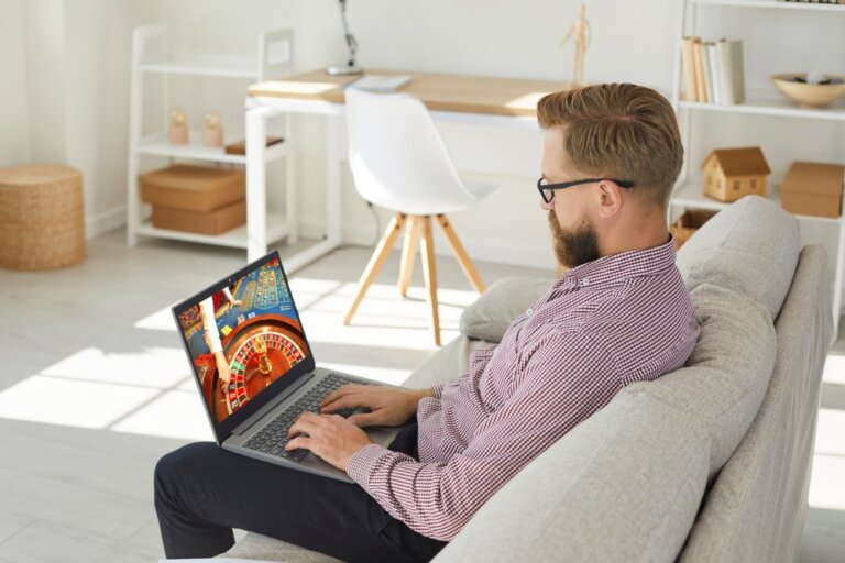 Young,Man,Sit,Relax,On,Sofa,Play,Casino,Online,On