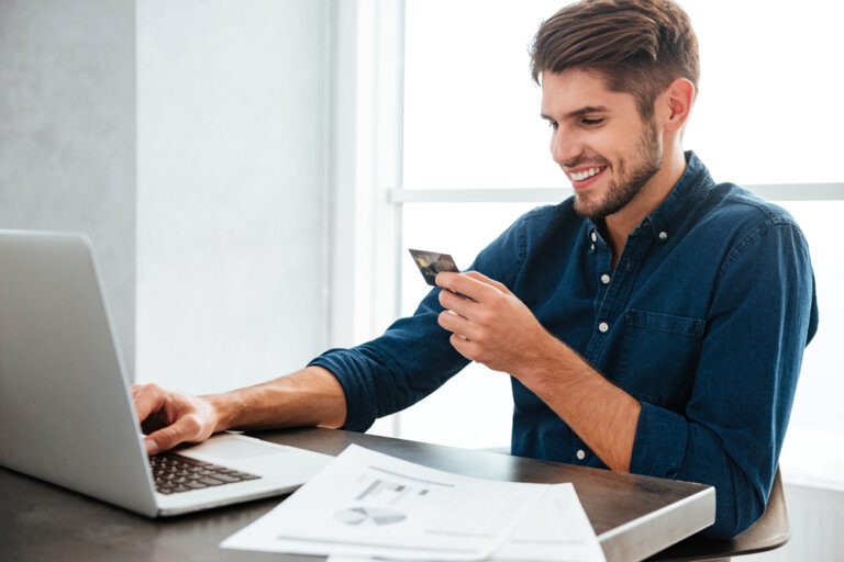 Photo,Of,Young,Man,Holding,A,Credit,Card,And,Typing.