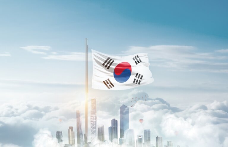 South,Korea,National,Flag,Waving,In,Sky,With,Modern,Building